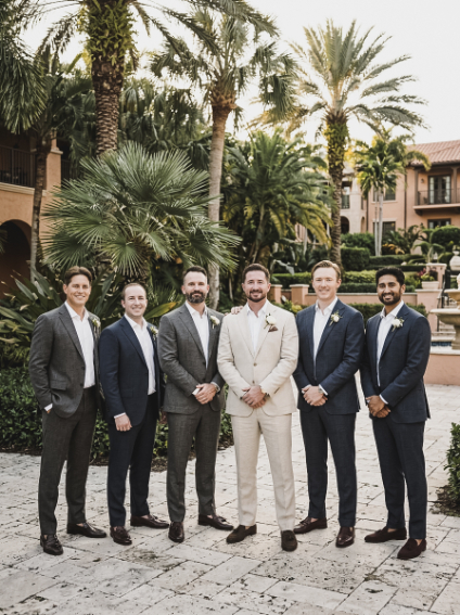 Six men in suits standing together in a line outdoors in front of palm trees.